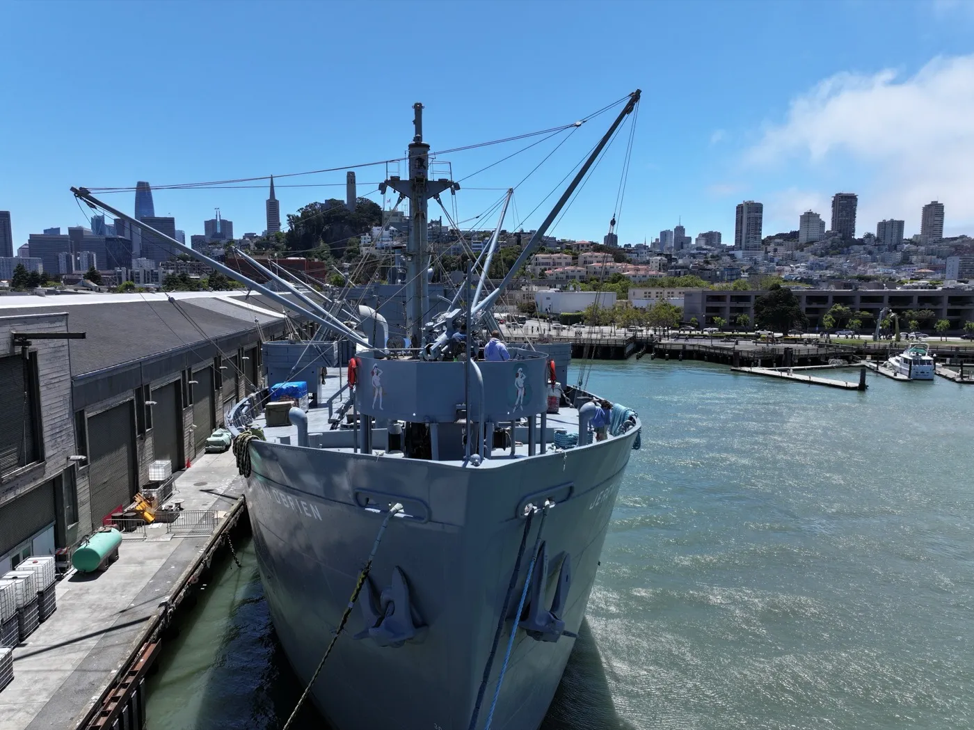 Forward mast and cargo booms against SF skyline